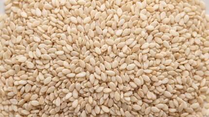 Fototapeta premium A vibrant close-up of a pile of white sesame seeds showcasing their smooth texture and pale color creating a clean and bright natural background