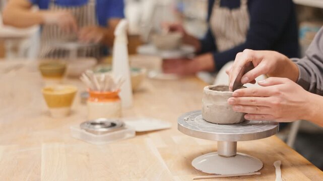 Closeup of female hands sculpting at a table in a pottery studio. High quality 4k footage