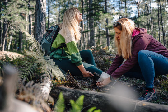 Woman helping injured friend during forest hike