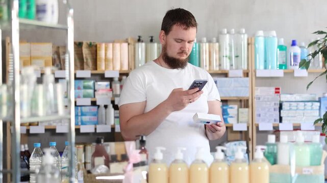 Young man buyer scanning qr code for box of ointment in pharmacy
