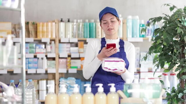 Near display case in pharmacy, young builder woman scans barcode on feminine pads. Client collects customer information online, seek reviews and recommendations for use