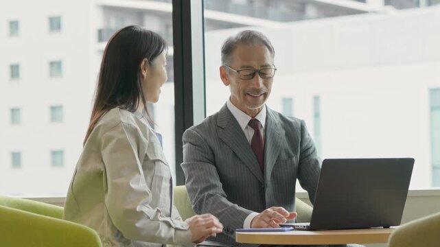 作業着の女性とスーツ姿の男性