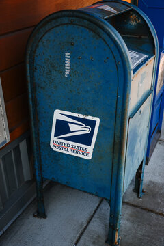Ketchikan, Alaska, USA - July 26, 2025: A weathered blue United States Postal Service (USPS) collection mailbox on a sidewalk in downtown Ketchikan