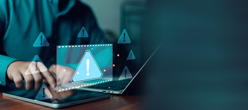 Cybersecurity warning alert interface with user using tablet and laptop, illustrating online security risk, data protection, phishing attack, malware detection, and digital privacy concept.