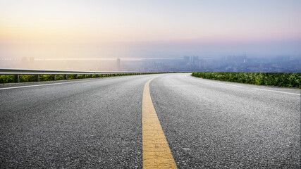 Naklejka premium Curved Asphalt Highway Overlook At Dusk Over City
