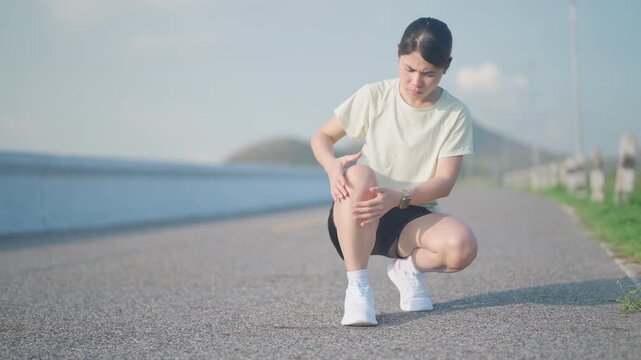 Young adult female runner with knee pain from ACL injury or patellofemoral syndrome. woman having joint ache, ligament tear or patellar tendinitis during running. Sports medical and healthcare concept