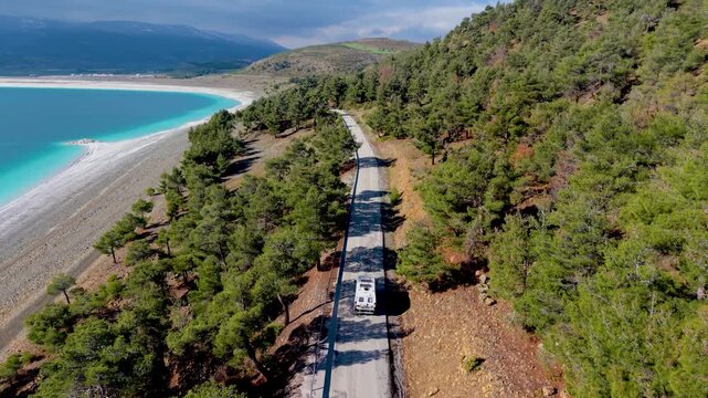 A camper van at the road of Salda Golu Lake in Turkey, often dubbed the Maldives of Turkey. Clear blue waters, lush greenery, and tranquil landscapes create a perfect getaway for travel lovers.