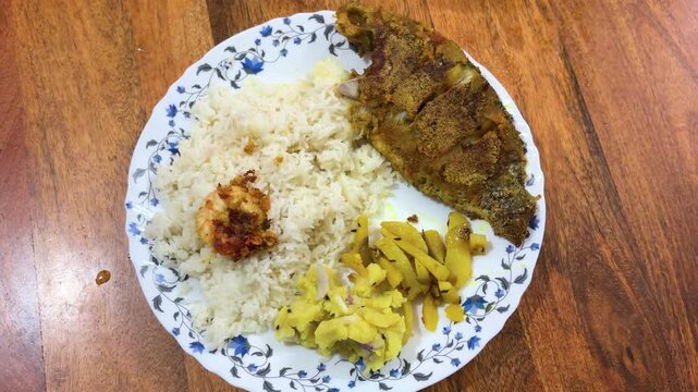 indian meal with rice fried fish and vegetable side dishes on plate