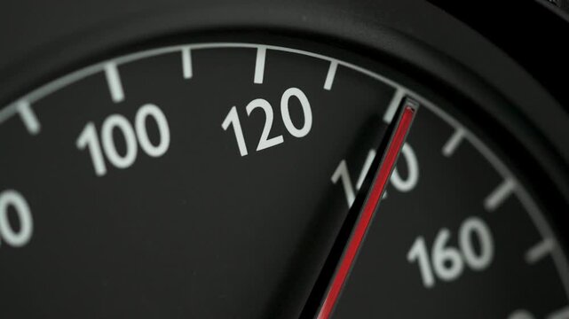 Close-up of a car speedometer with a red needle indicating high speed, with blurred blue police lights in the background. Concept image for speeding, traffic violations, police pursuit, emergency resp