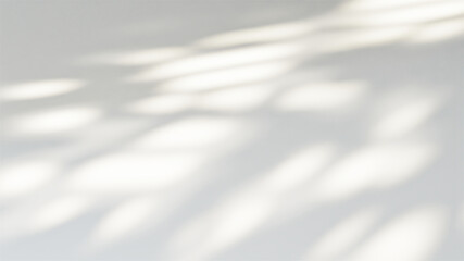 Sunlight casting a blurred window shadow on a neutral white wall background