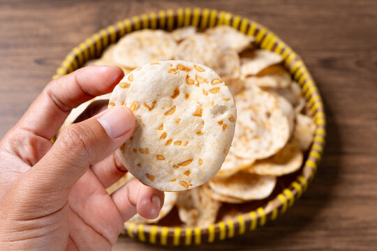 Close up hand holding traditional keripik tempe displaying intricate soybean texture