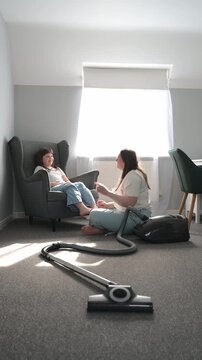 Mother and daughter celebrating with high five after cleaning home