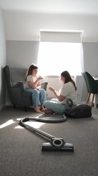 Mother sharing apple with daughter after cleaning home together