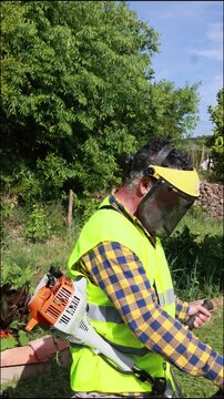 Gardener mowing grass with string trimmer