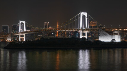 Fototapeta premium Night View of Suspension Bridge with City Lights and Reflections