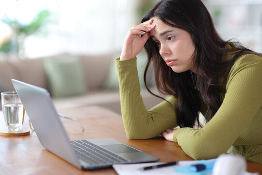 Worried student complaining checking bad news on laptop