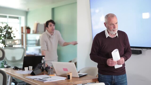 Elderly man quits his job. His younger boss yells at him and throws him out. High quality 4k footage