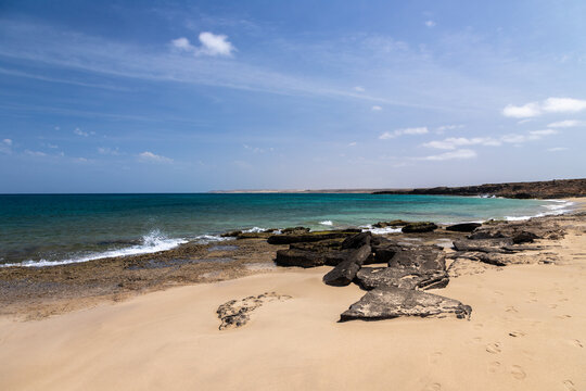 The beautiful white sandy beach with the unique sandscaped boulders on the waterfront of the Atlantic ocean near the village of Pedra de Luma on the island of Sal in Cape Verde. This kind of deserted 