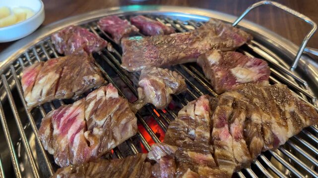 Enjoying grilled meat at a barbecue restaurant during dinner time with friends in a lively atmosphere in the city