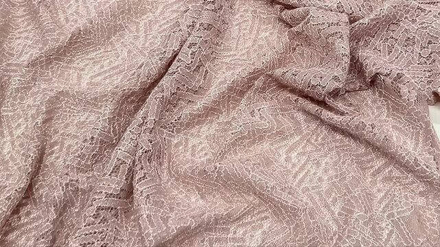 Elegant mauve textile featuring an intricate geometric lace pattern woven with shimmering metallic threads for a subtle glitter effect perfect for formal evening gowns and luxury bridal wear accents