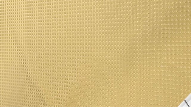 A durable gold faux leather material features an embossed diamond grid texture with a soft white felt backing making it ideal for upholstery car interiors and luxury craft projects