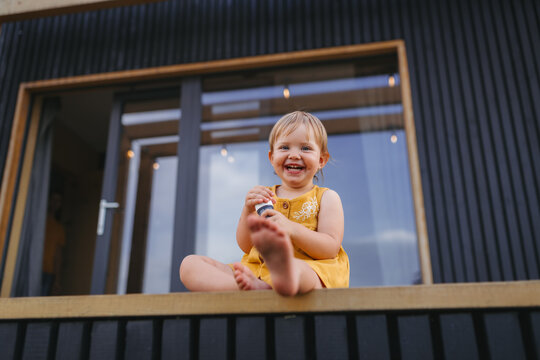 Small child playing outdoors, weekend away in container house in countryside.