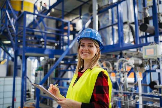 Woman worker woring in industrial factory, programming machine.