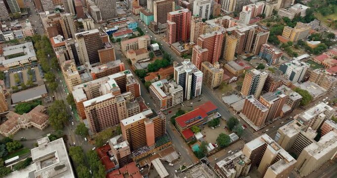 4K drone flyover above a typical Johannesburg district in South Africa. Aerial view of city traffic, busy streets, and dense urban architecture within the metropolitan residential area