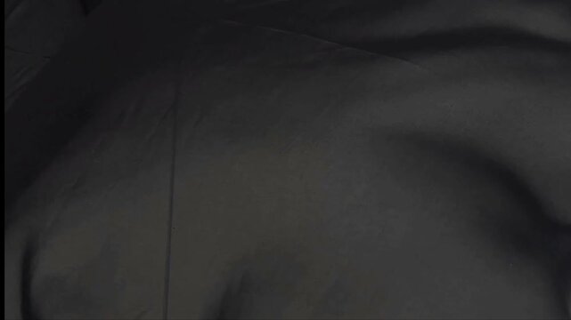 A lightweight black chiffon material features a smooth sheer texture and elegant drape providing a versatile aesthetic for sophisticated evening wear formal gowns and delicate fashion apparel.