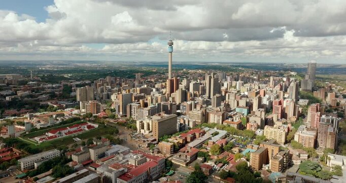 4K drone orbit establishing shot of Hillbrow district and tower in Johannesburg. South African urban landscape featuring dense city architecture and iconic landmark skyline panorama.
