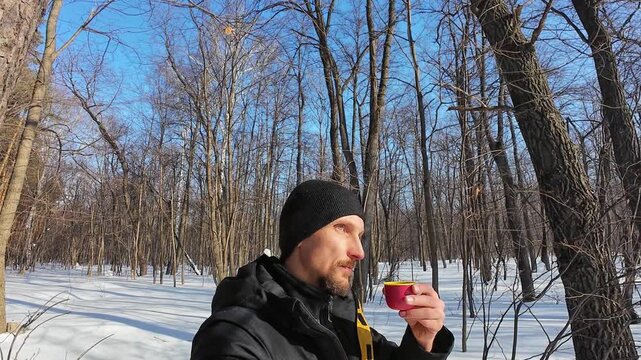 White Man Vlogging Winter Forest Walk Holding Pink Cup, Beanie And Yellow Jacket, Crisp Sunlight On Frosty Trail, Expressive Smile And Candid Narration, Travel Narrative And Energetic Outdoor Content