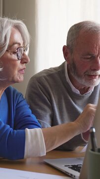 Senior couple discussing finances with laptop