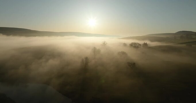 Sunrise over foggy valley and still river