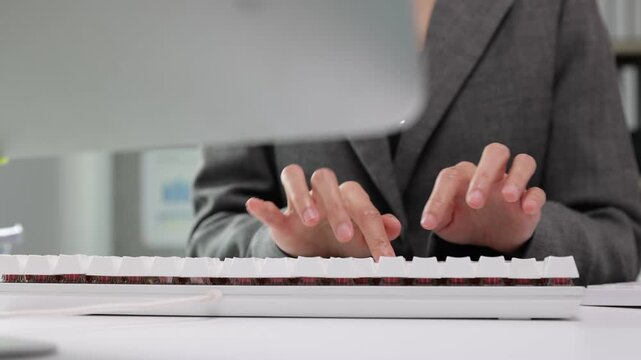 Businesswoman hands typing on a mechanical keyboard at the office desk. Close-up of female hands typing on a computer keyboard. Professional businesswoman working in an office, entering data or coding