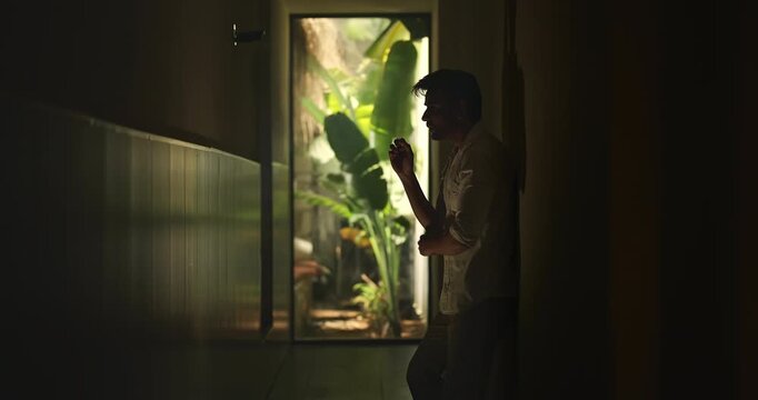 Indian young adult gen z sad stress man guy look upset feel bad hurt head ache in dark living room. Alone tired male boy think deep suffer low health issue lost job fail guilt indoor house home place