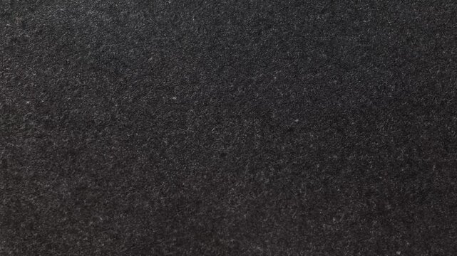 Dark textured surface fills the entire frame with no distinct objects or features