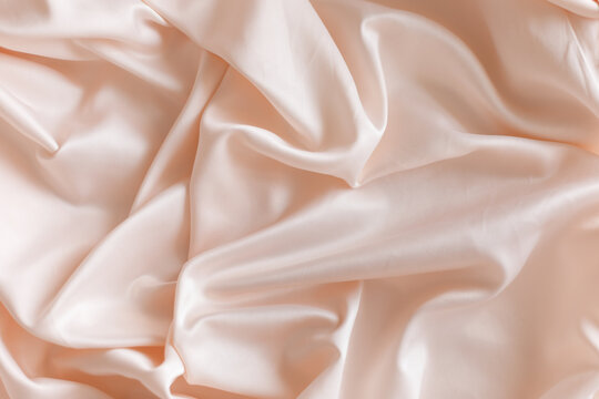 Pink silk satin fabric texture background soft folds