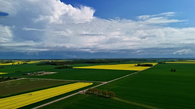 A high-altitude drone shot looks down on a colorful patchwork of rural agricultural lands.