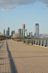 Fototapeta premium Sunlit City Scene. Sunlit Promenade Along River With Skyline And Vibrant Activity new york