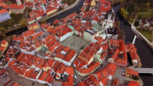 Cesky Krumlov market square with red rooftops and St. Vitus church, overhead drone shot, Czech Republic
