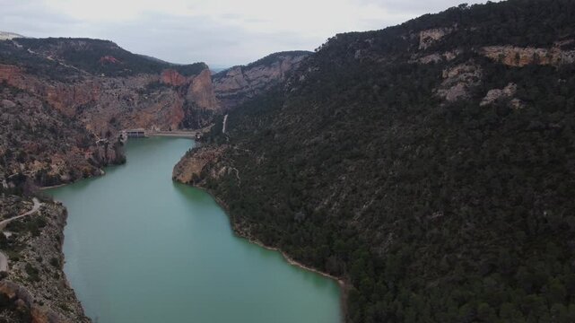 4K aerial lateral drone shot sliding across the massive J&uacute;car River reservoir in Spain, surrounded by deep canyons and lush green vegetation under a wide scenic sky