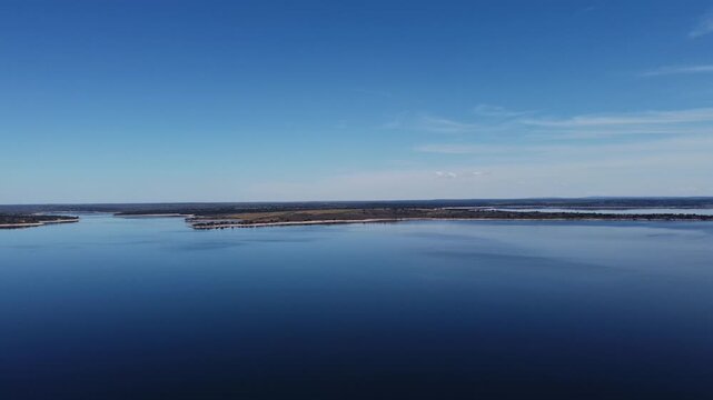 4K aerial panoramic rotation over the massive Almendra Reservoir in Salamanca, Spain. Stunning view of the unique blue water and horizon under a bright sunny sky.