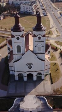 Vertical screen Aerial View Holy Cross Church Lomza, Baroque Twin Towers, Empty Forecourt And Curved Steps, Long Shadows And Soft Morning Light, Manicured Lawns And Quiet Streets, Frontal