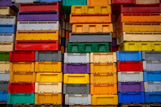 Stacked colorful fish crates at fishing harbor in Sassnitz on Ruegen island, Germany. Maritime industry, logistics and commercial fishing concept.