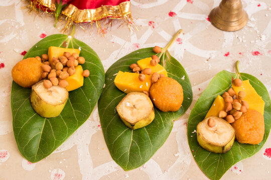 prasad having mango, banana, chana and laddu on the banyan tree leaf for vat savitri