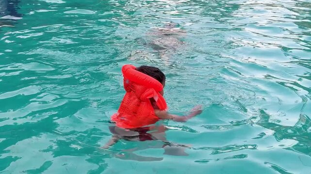 child enjoying swimming session in pool while wearing protective life vest