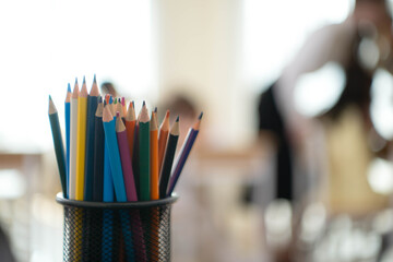 Naklejka premium Close up of colorful pencils in a container inside a classroom