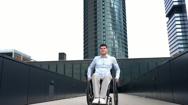 Young confident businessman with a physical disability moving forward in his wheelchair through a modern city with skyscrapers in the background