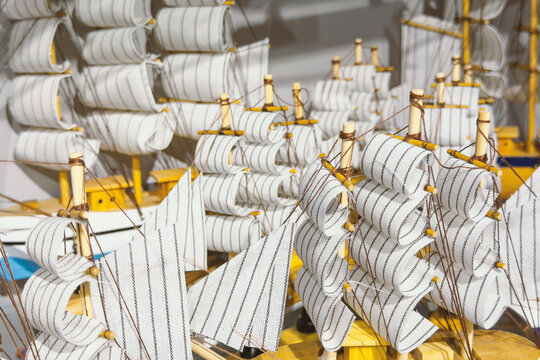 Wooden model sailing ships with striped sails displayed together