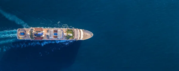 Fotobehang Zonsondergang Zee Aerial overhead view of a generic cruise ship sailing over the blue ocean with copy space as a concept for travel and tourism  © moofushi